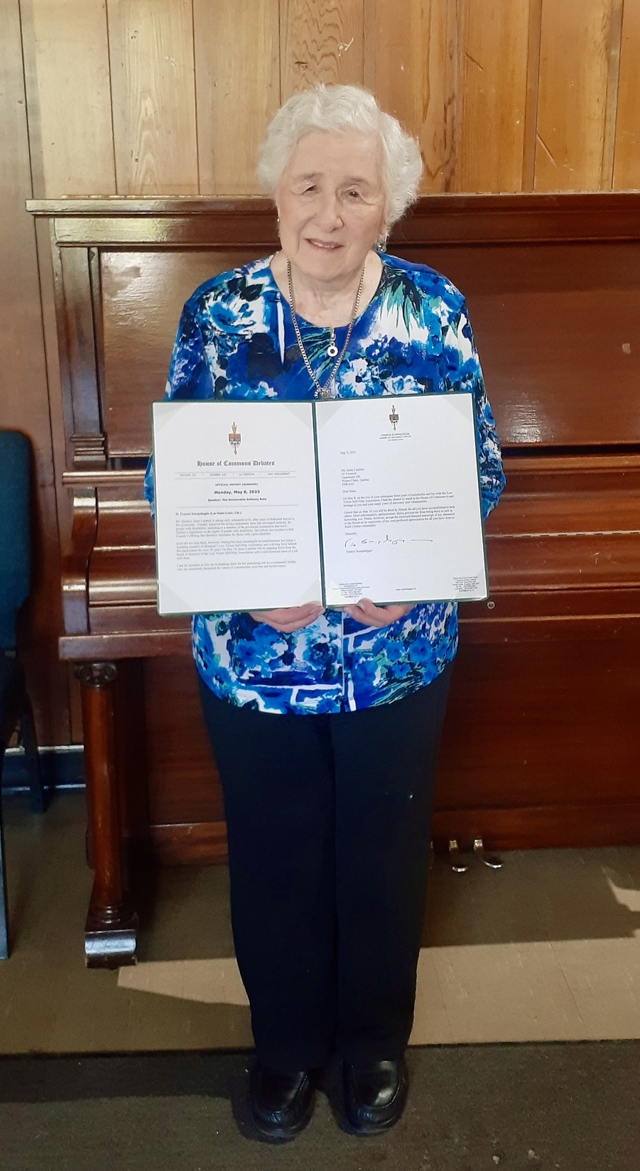 Irene Lambert is displaying the Tribute she received in the House of Commons by MP Francis Scarpaleggia.